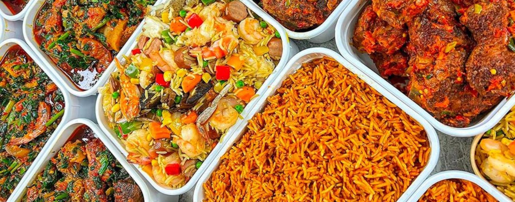 Trays of Nigerian jollof rice, fried rice, efo riro and peppered meat
